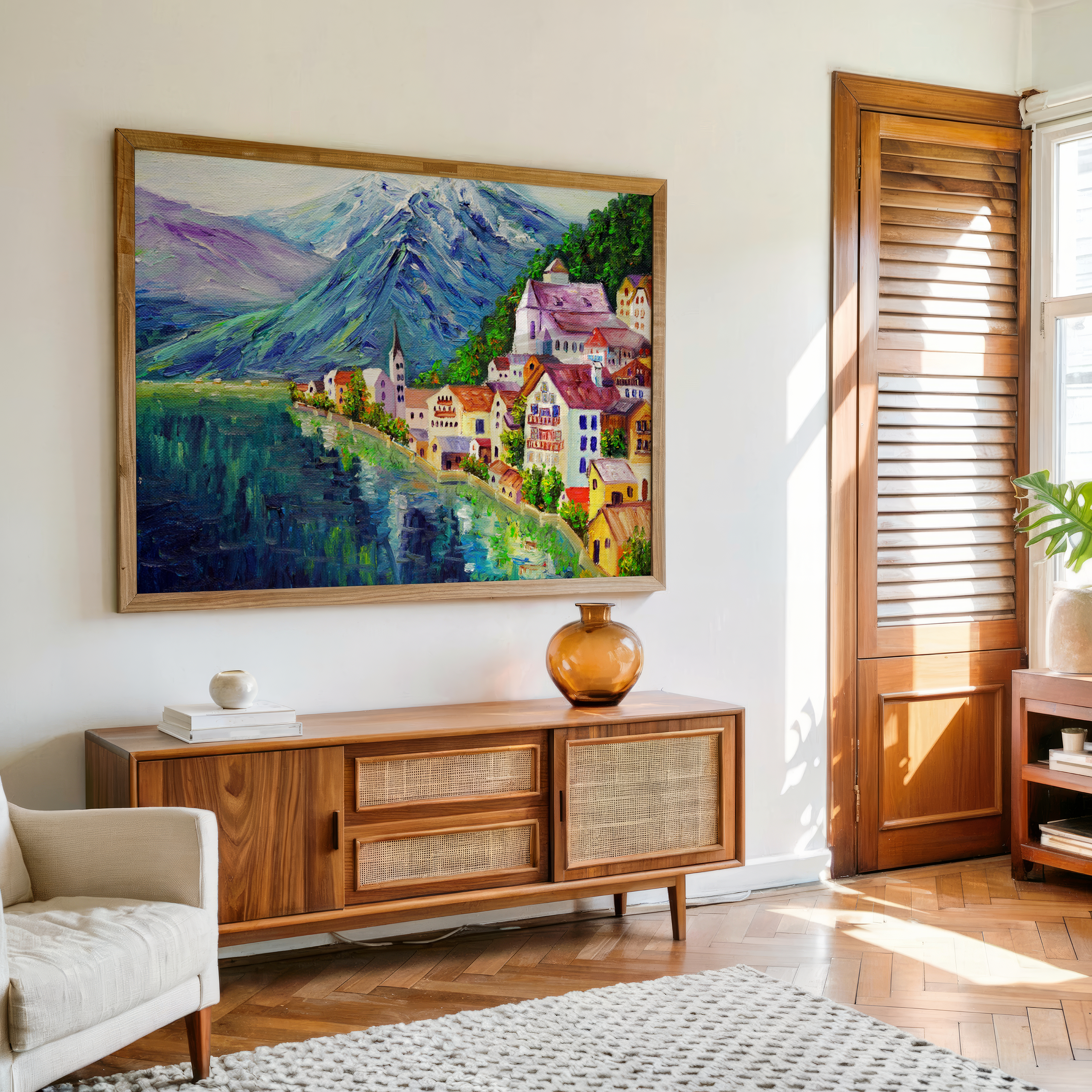 Living room with a large painting of a mountain village on the wall above a wooden cabinet.