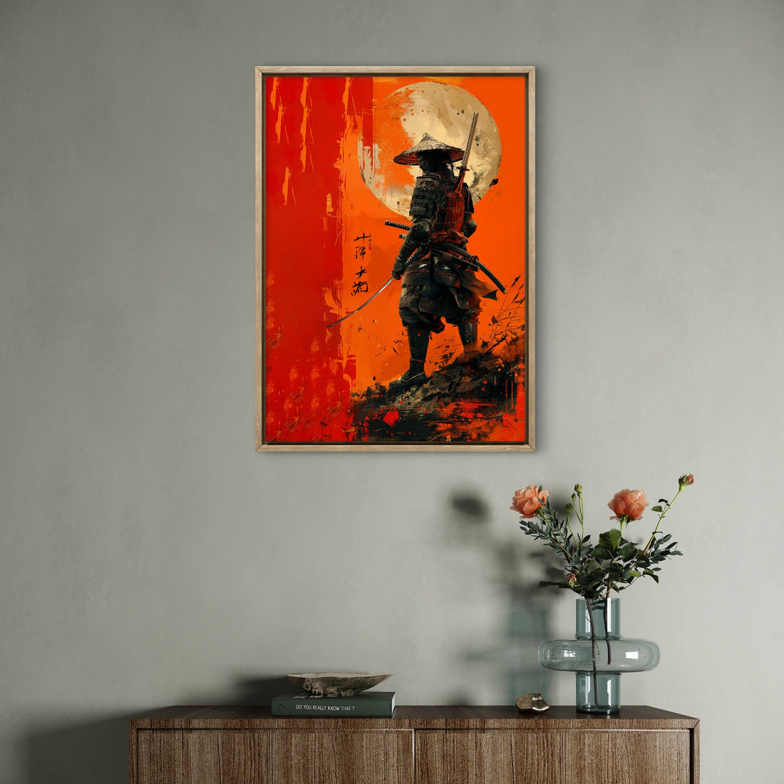 Framed artwork of a samurai on an orange background above a wooden cabinet with a vase of flowers.