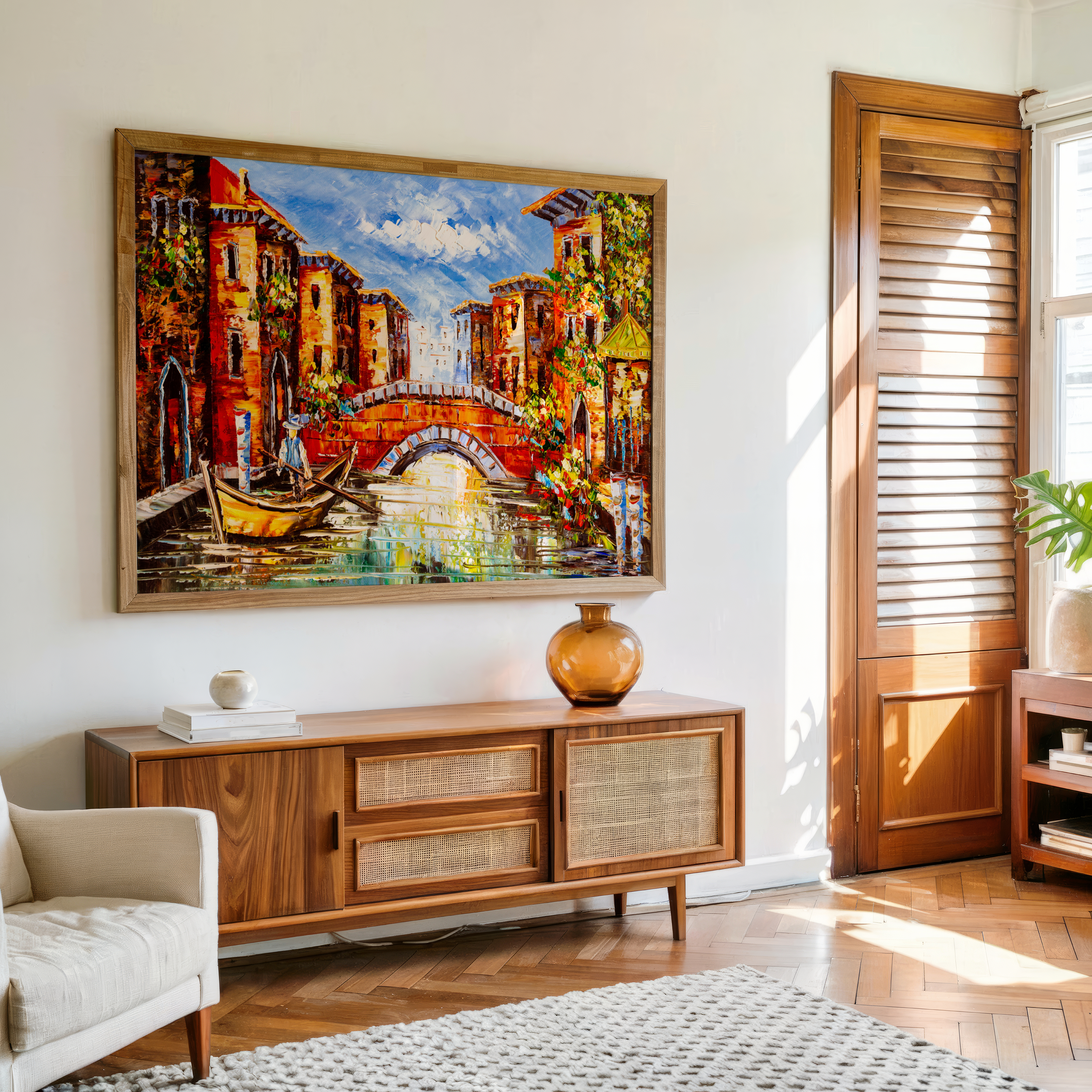 Living room with a large painting of a canal scene on the wall above a wooden sideboard.